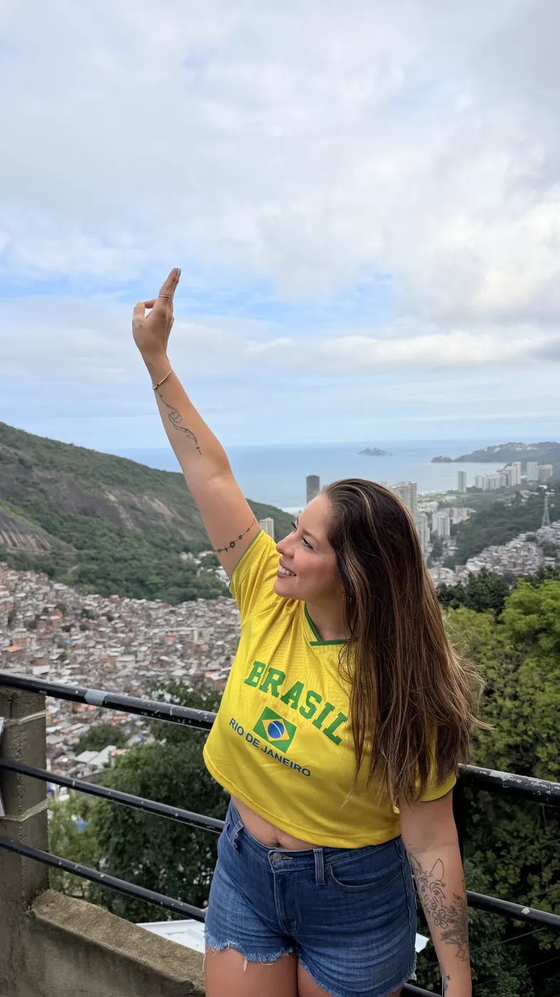 Turista apontando para a vista da comunidade a partir do mirante.