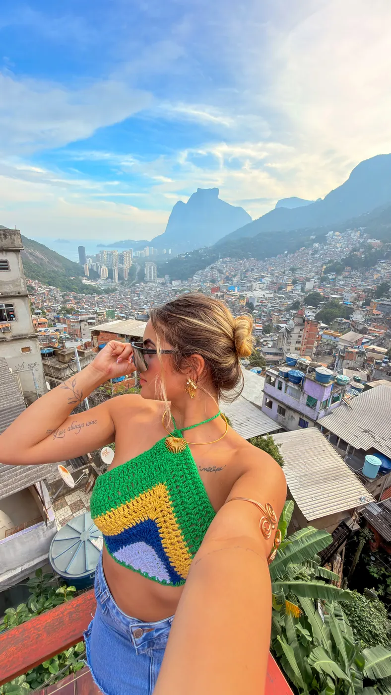 Turista de costas no mirante, olhando a Rocinha e a Pedra da Gávea.